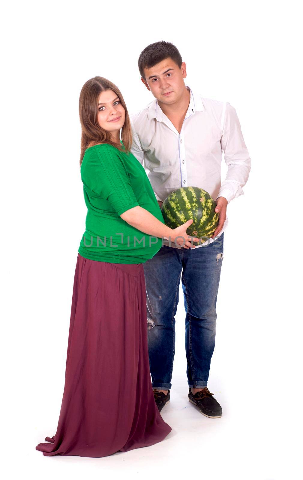 A man and a pregnant woman are holding a large watermelon in their hands. isolated on white background by aprilphoto