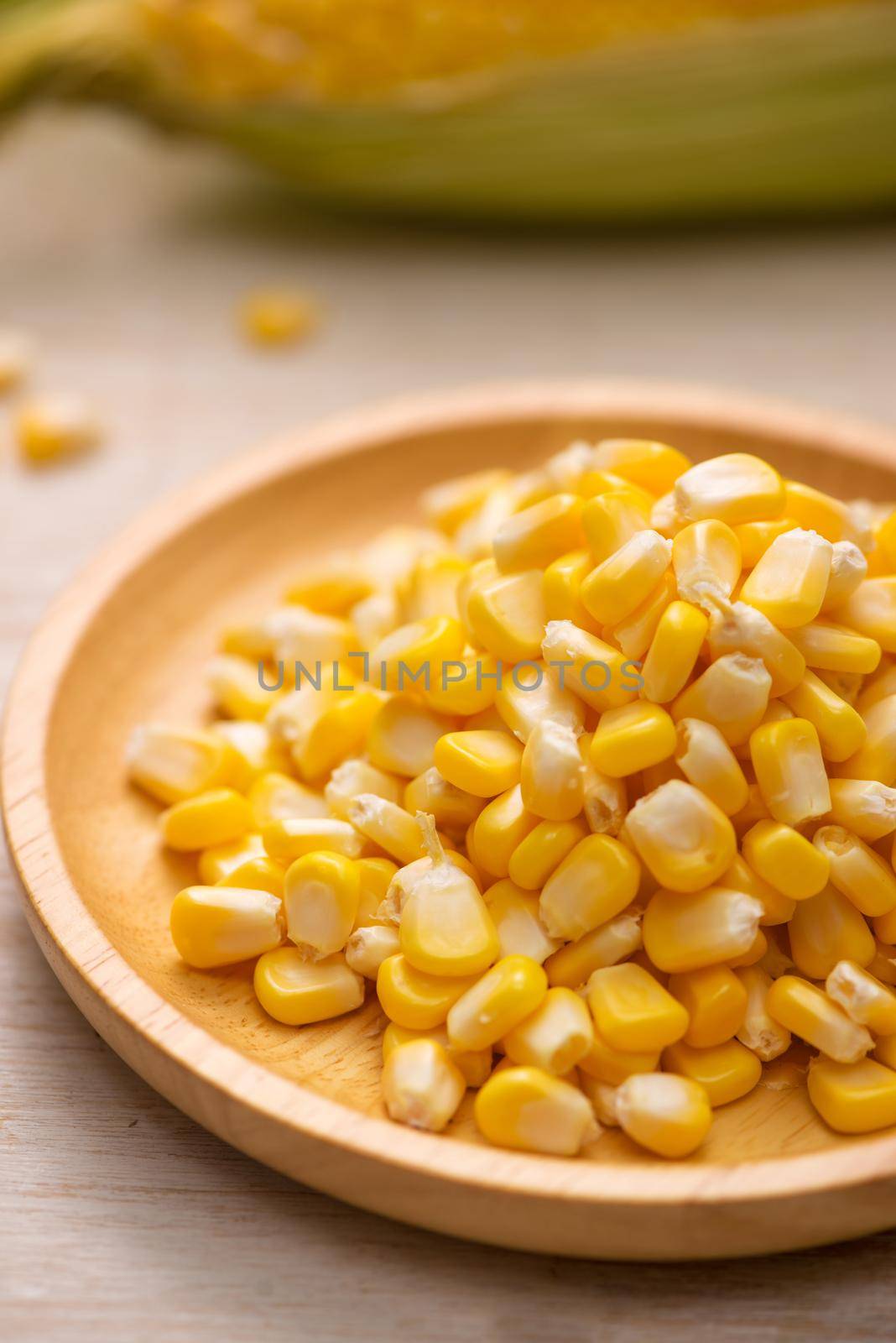 Sweet corn seeds on a wooden plate 