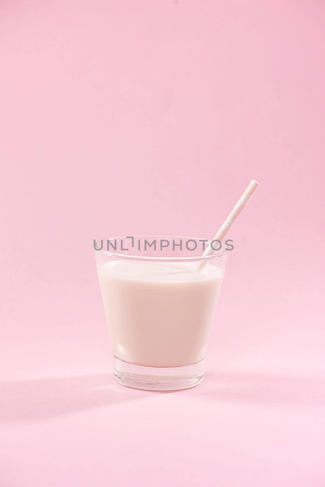 Dairy products. A glass of milk on a pink background. by makidotvn