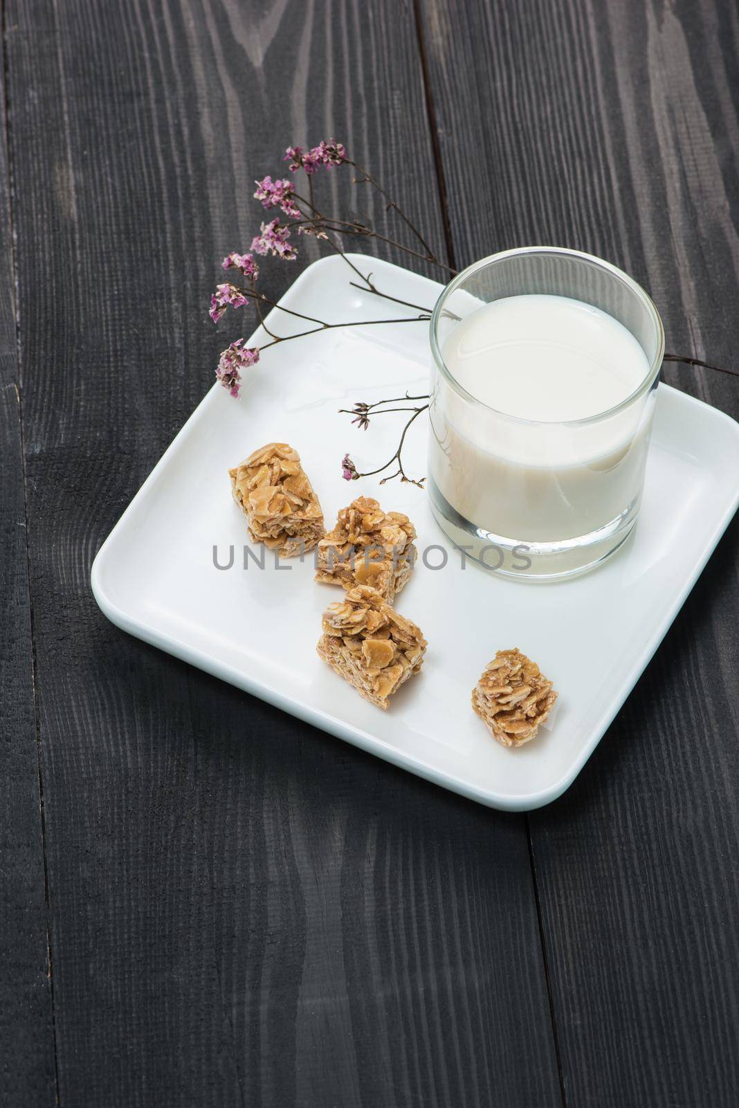 Dairy products. A glass of milk serve with almond candies on a rustic wooden table. by makidotvn