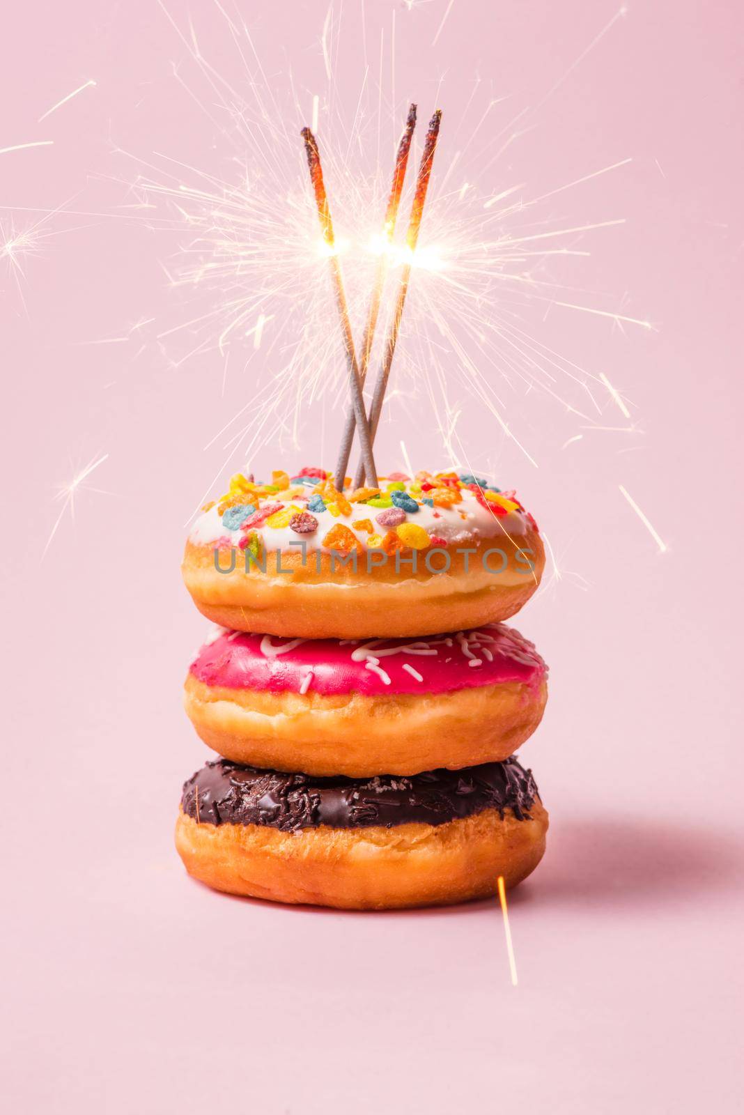 Delicious donuts for birthday on pastel pink background. by makidotvn