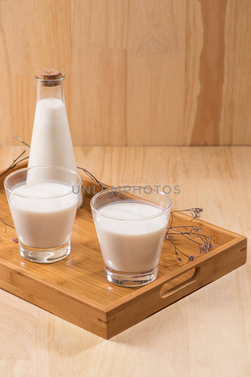 Dairy products. A bottle of milk and glass of milk on a wooden table. by makidotvn