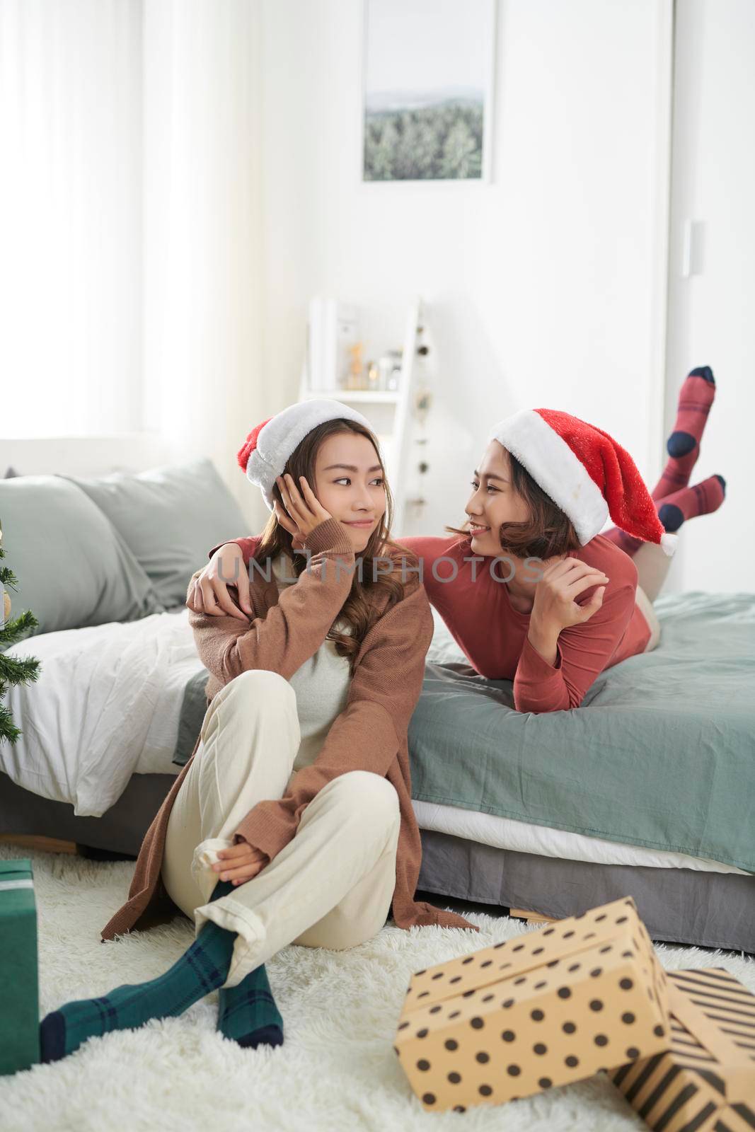 Young woman best friends celebrating Xmas in house
