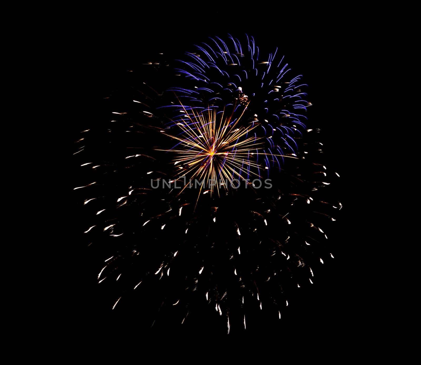 Colorful celebration fireworks isolated on a black sky background.