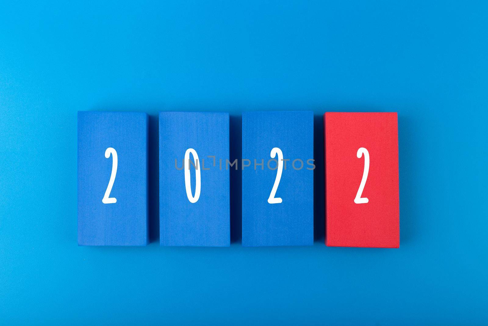 New Year 2022 blue minimal trendy concept. Modern elegant composition with blue toy blocks with written 2022 numbers on blue background