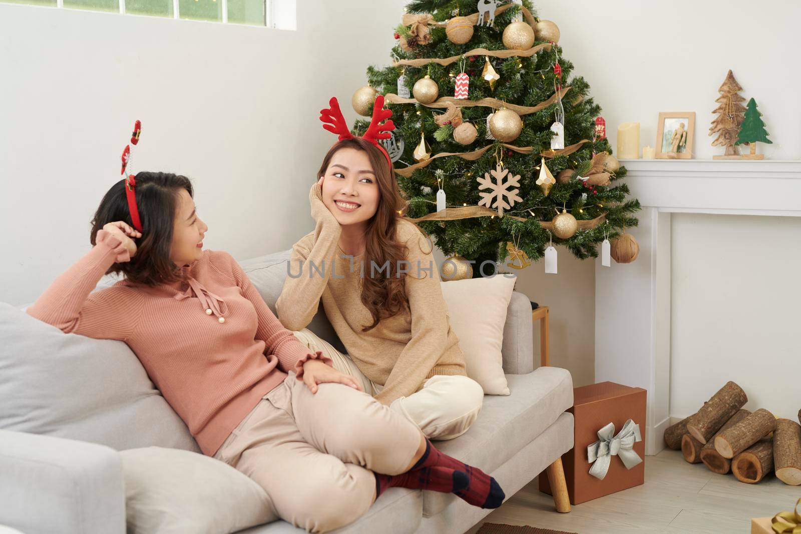 Two beautiful girls near the Christmas tree waiting for gifts