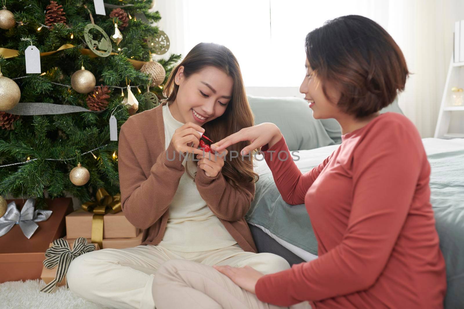 Woman painting one's nails in red, closeup