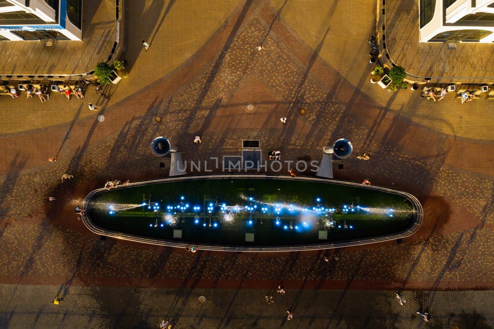 Top view of the city fountain in the new district of Minsk Mayak hot summer and vacationing people.People relax and walk near a large fountain in the city.Belarus.