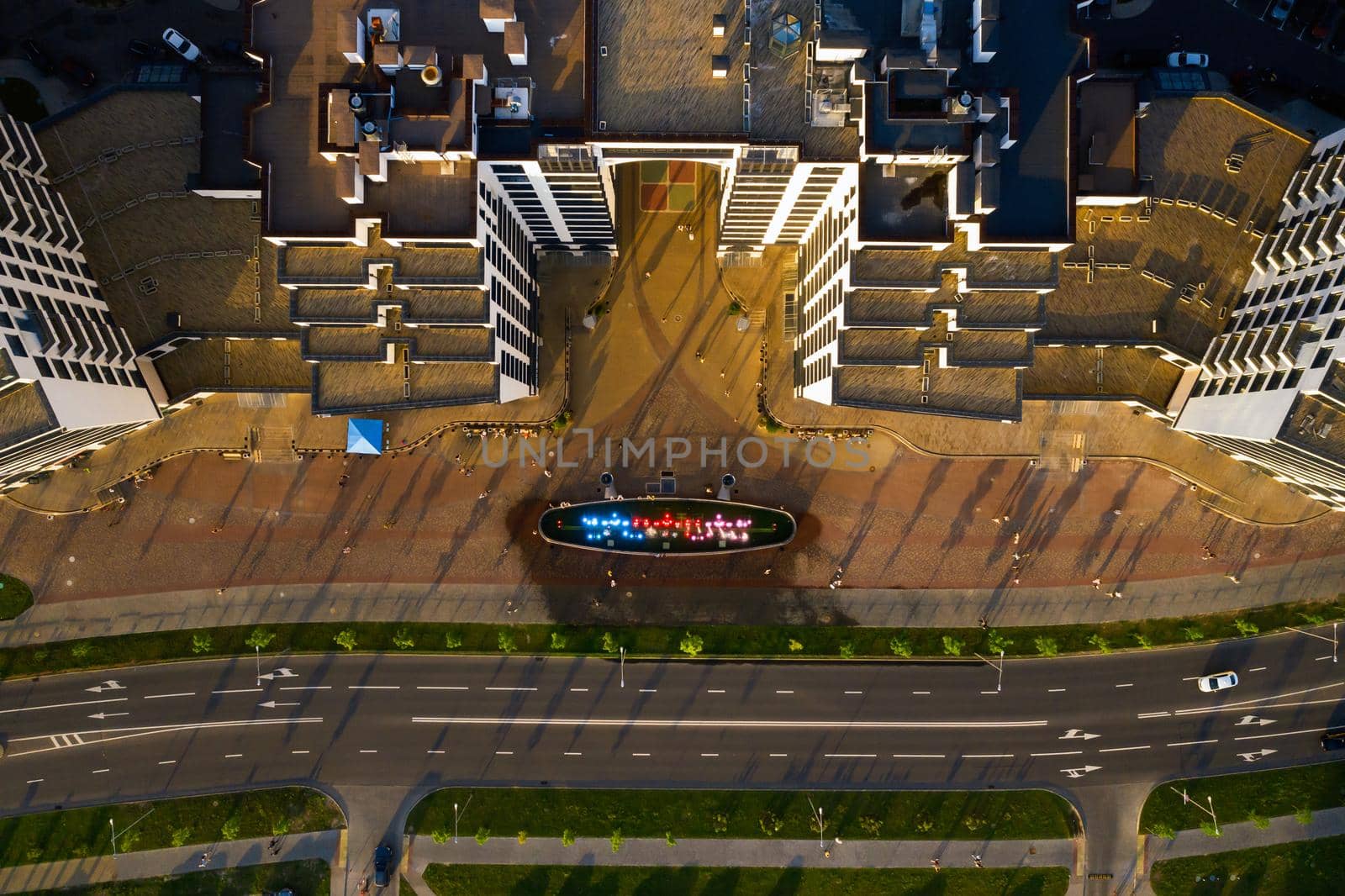 Top view of the city fountain in the new district of Minsk Mayak hot summer and vacationing people.People relax and walk near a large fountain in the city.Belarus.