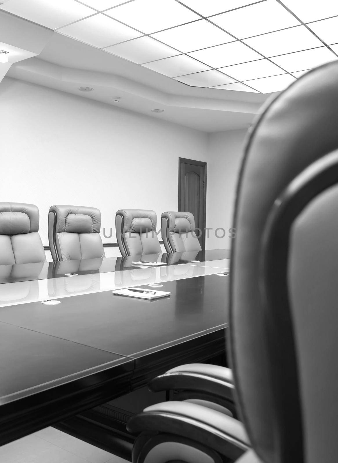 conference room with wooden table and beige leather armchairs