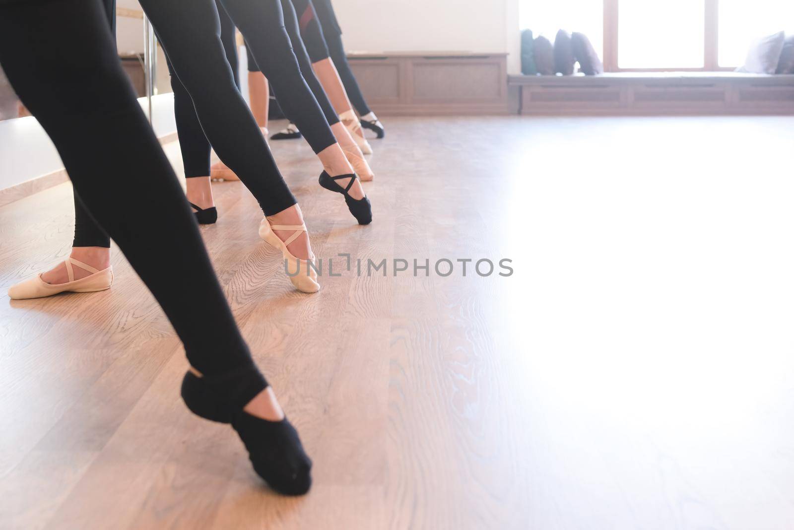 The elegant legs of ballet dancers standing in a row on their toes by Nickstock