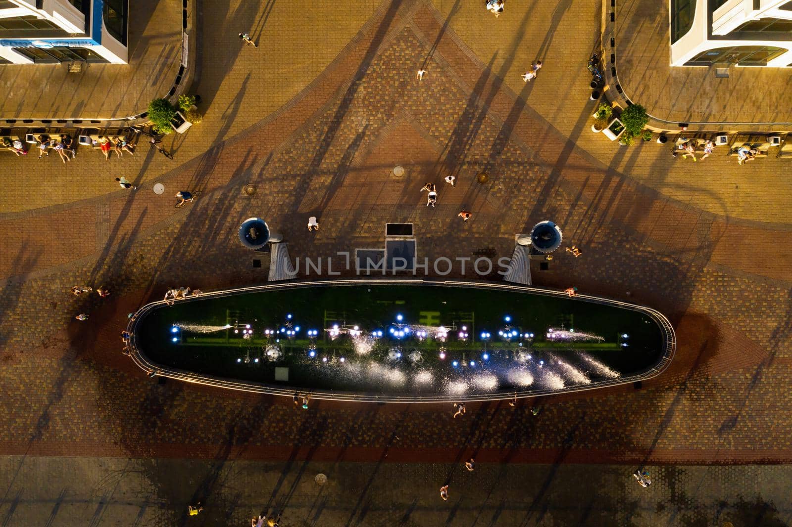 Top view of the city fountain in the new district of Minsk Mayak hot summer and vacationing people.People relax and walk near a large fountain in the city.Belarus.