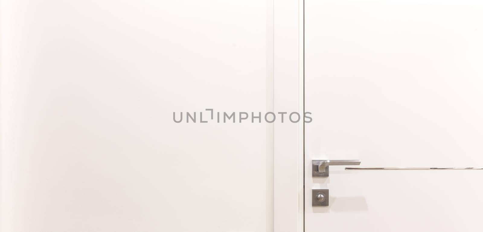 Metalic doorknob on a white modern door
