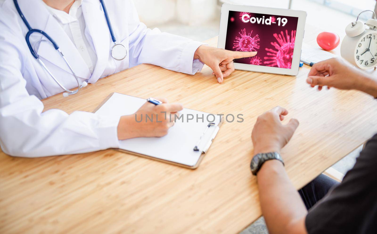 Medical Doctor Advising Coronavirus Disease and Health Care Consulting to Her Patient in Examination Room, Female Physician Doctor is Explaining Corona Virus Pandemic to Patient. Coronavirus Crisis by MahaHeang245789