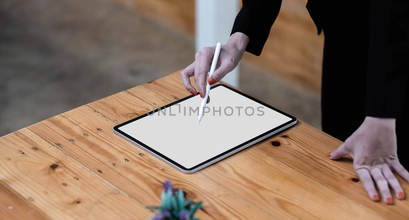 Close up hand of business woman working desk drawing on a white blank screen computer tablet.