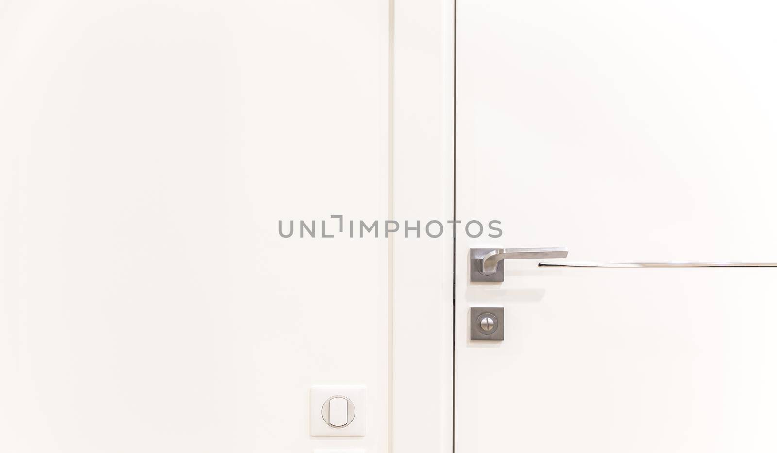 Metalic doorknob on a white modern door
