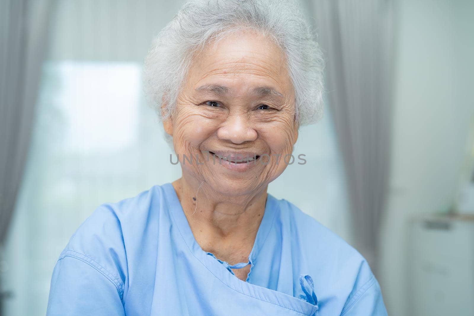 Asian senior or elderly old lady woman patient smile bright face while sitting on bed in nursing hospital ward, healthy strong medical concept. by pamai