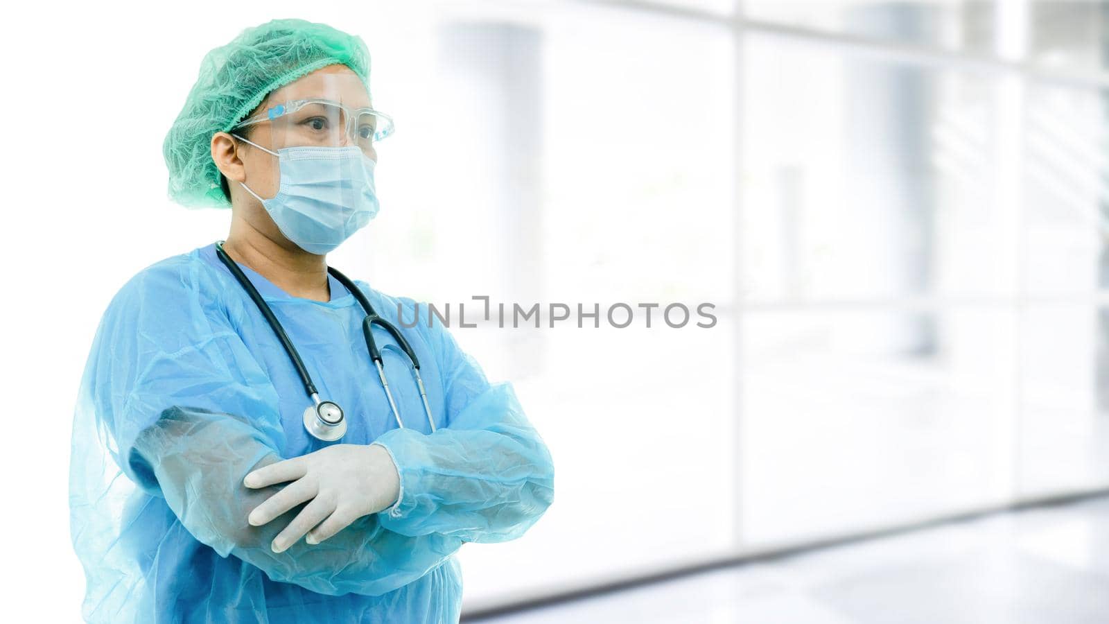 Asian doctor wearing face shield and PPE suit new normal to check patient protect safety infection Covid-19 Coronavirus outbreak at quarantine nursing hospital ward. by pamai