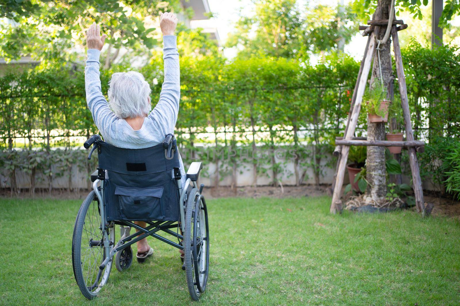 Asian senior or elderly old lady woman patient exercise on wheelchair with happy fresh enjoy in home garden, healthy strong medical concept by pamai