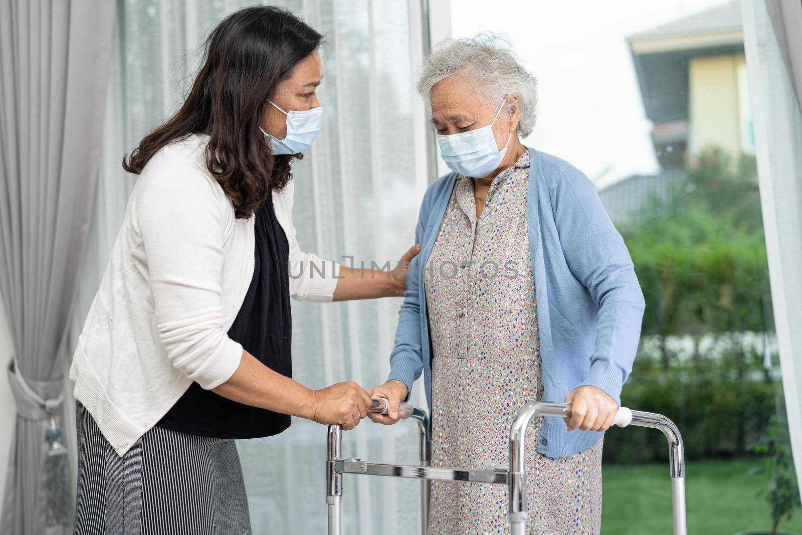 Help and care Asian senior or elderly old lady woman use walker with strong health while walking in hospital.