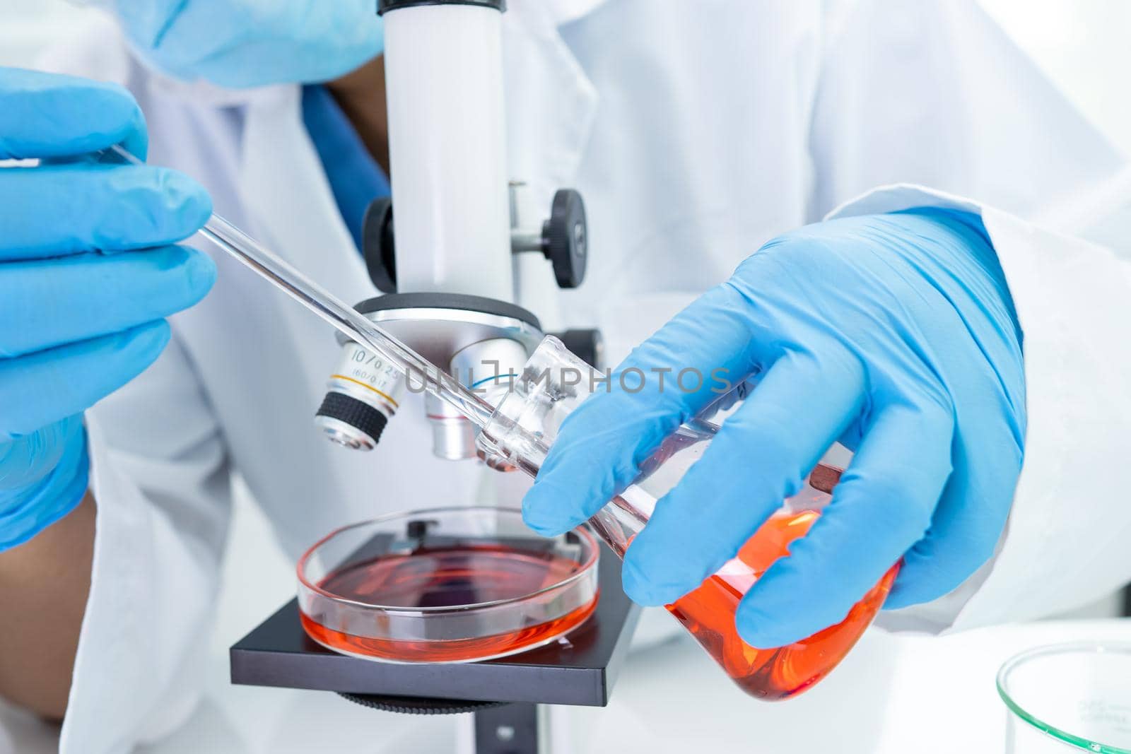 Asian scientist biochemist or microbiologist working research with a microscope in laboratory. For protect outbreak Coronavirus Covid19, bacteria and germs.