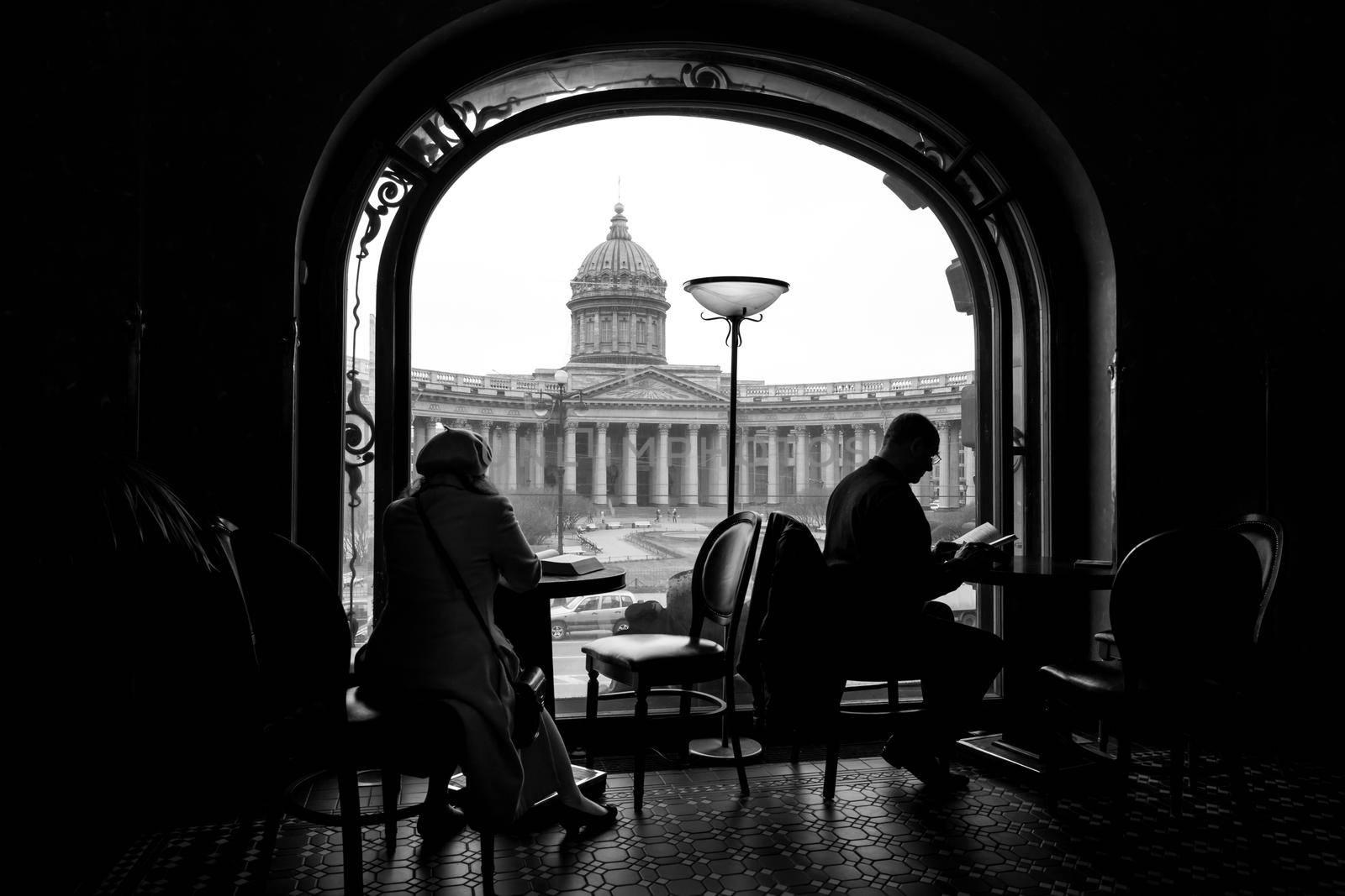Silhouette of woman and man reading books in a cafe in bookstore in Saint Petersburg Russia