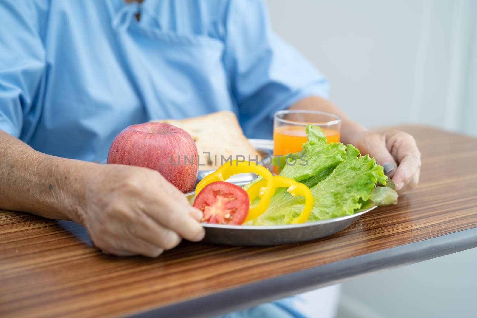Asian senior or elderly old lady woman patient eating breakfast vegetable healthy food with hope and happy while sitting and hungry on bed in hospital. by pamai