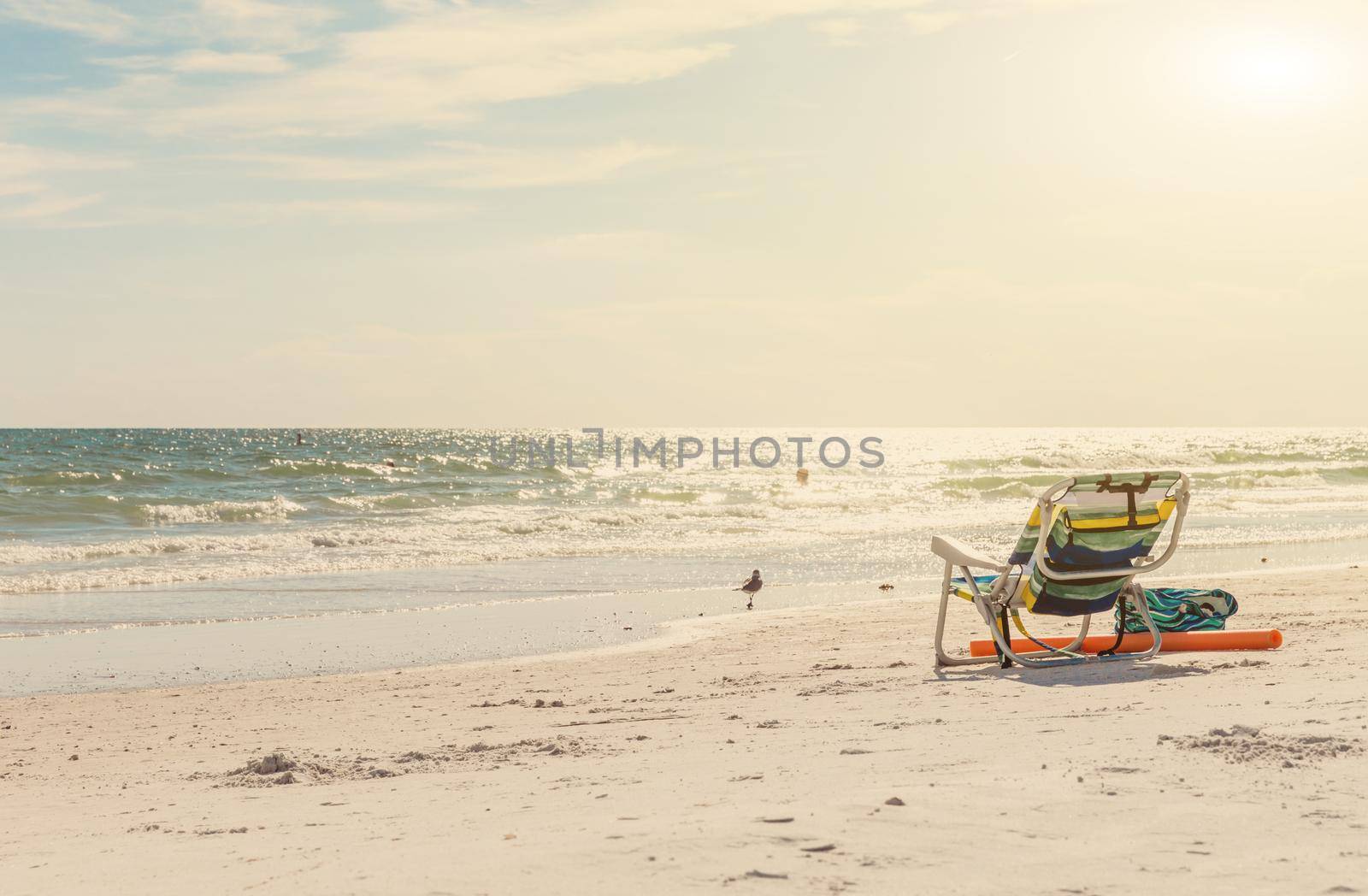 landscape of ocean and beach with chair and bag