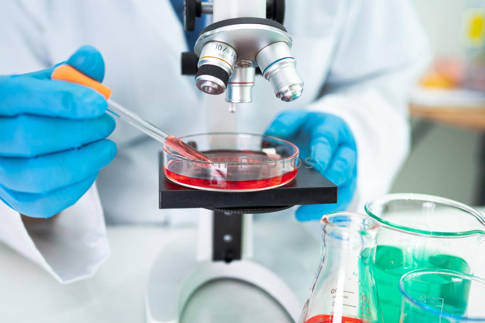 Asian scientist biochemist or microbiologist working research with a microscope in laboratory. For protect outbreak Coronavirus Covid19, bacteria and germs.