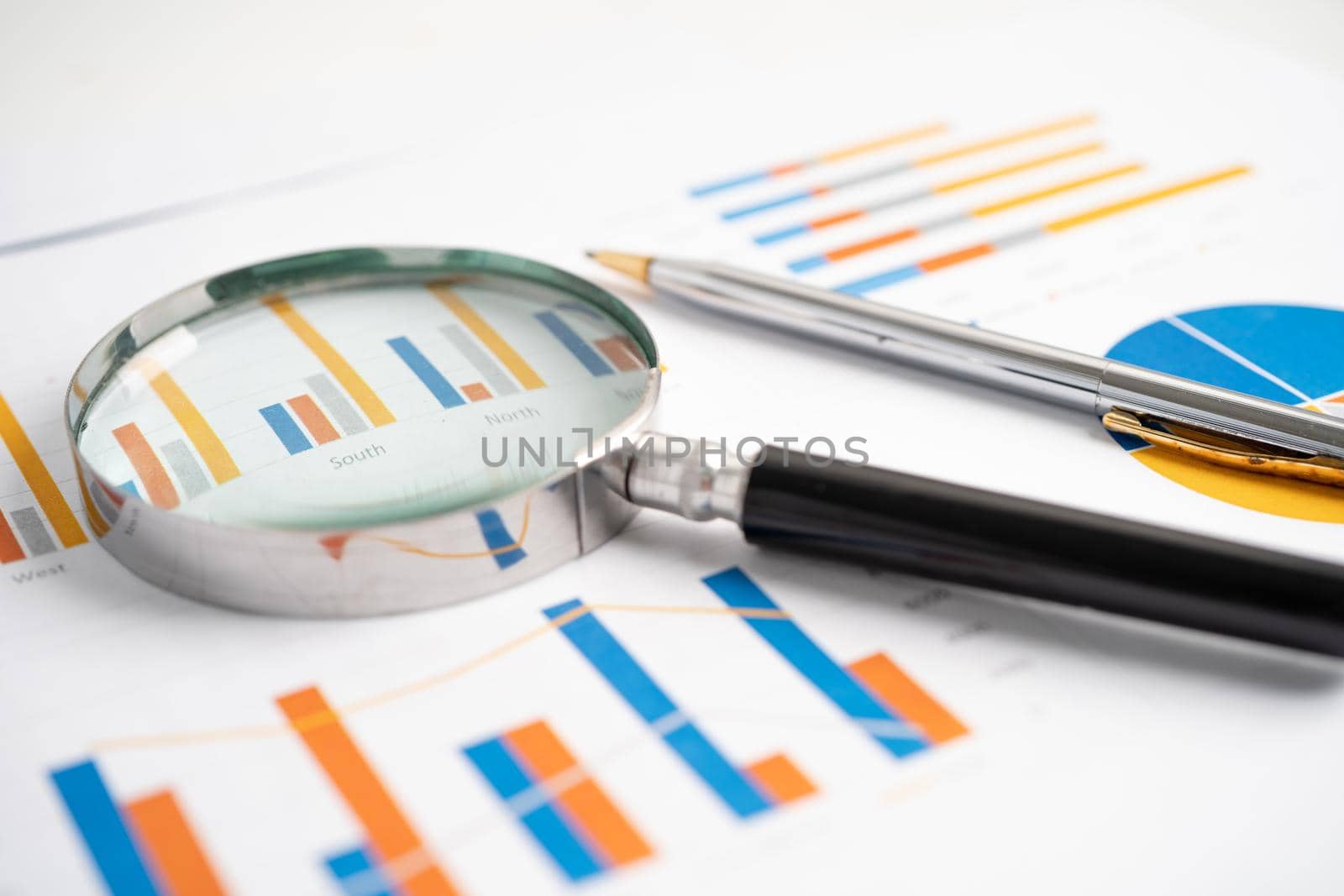 Magnifying glass on charts graphs paper. Financial development, Banking Account, Statistics, Investment Analytic research data economy, Stock exchange trading, Business office company meeting concept. by pamai
