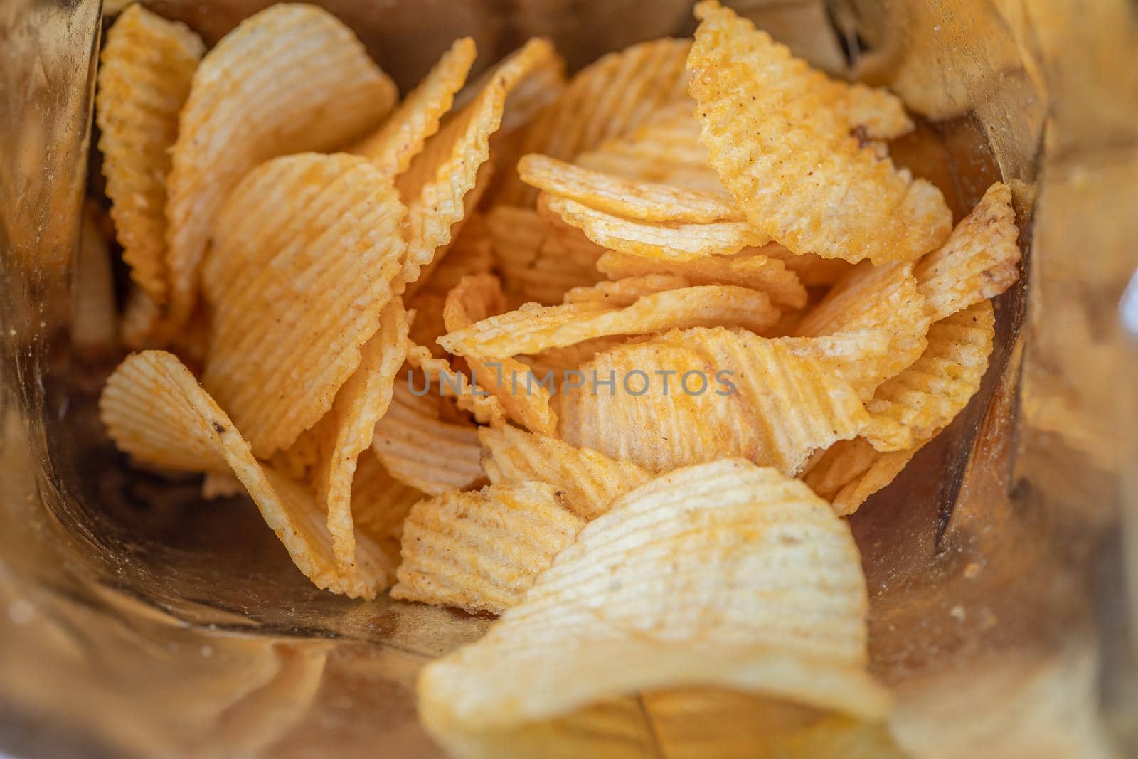 Potato chips, delicious BBQ seasoning spicy for crips, thin slice deep fried snack fast food in open bag. by pamai