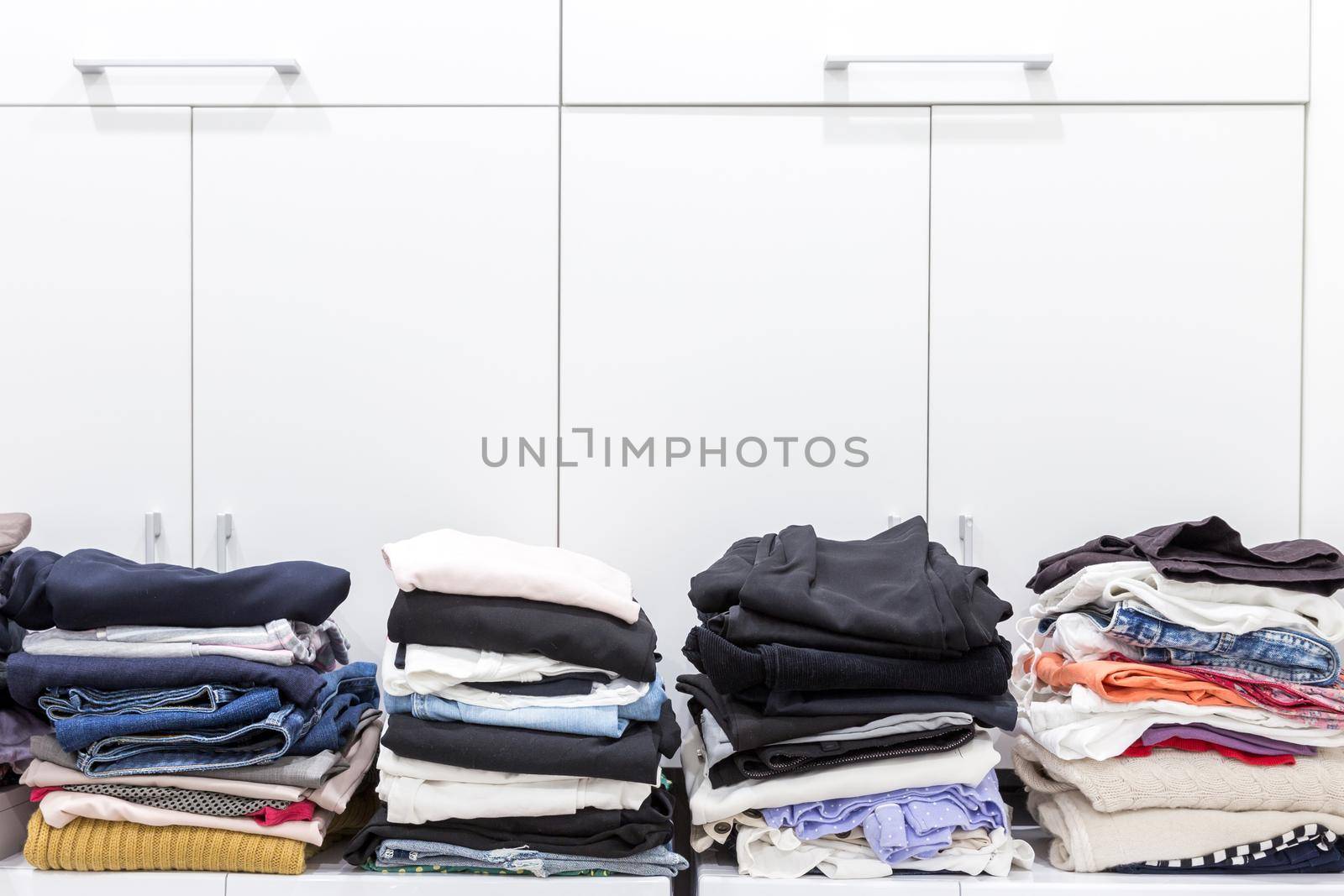 Stacks of clean clothes in utility room with copy space