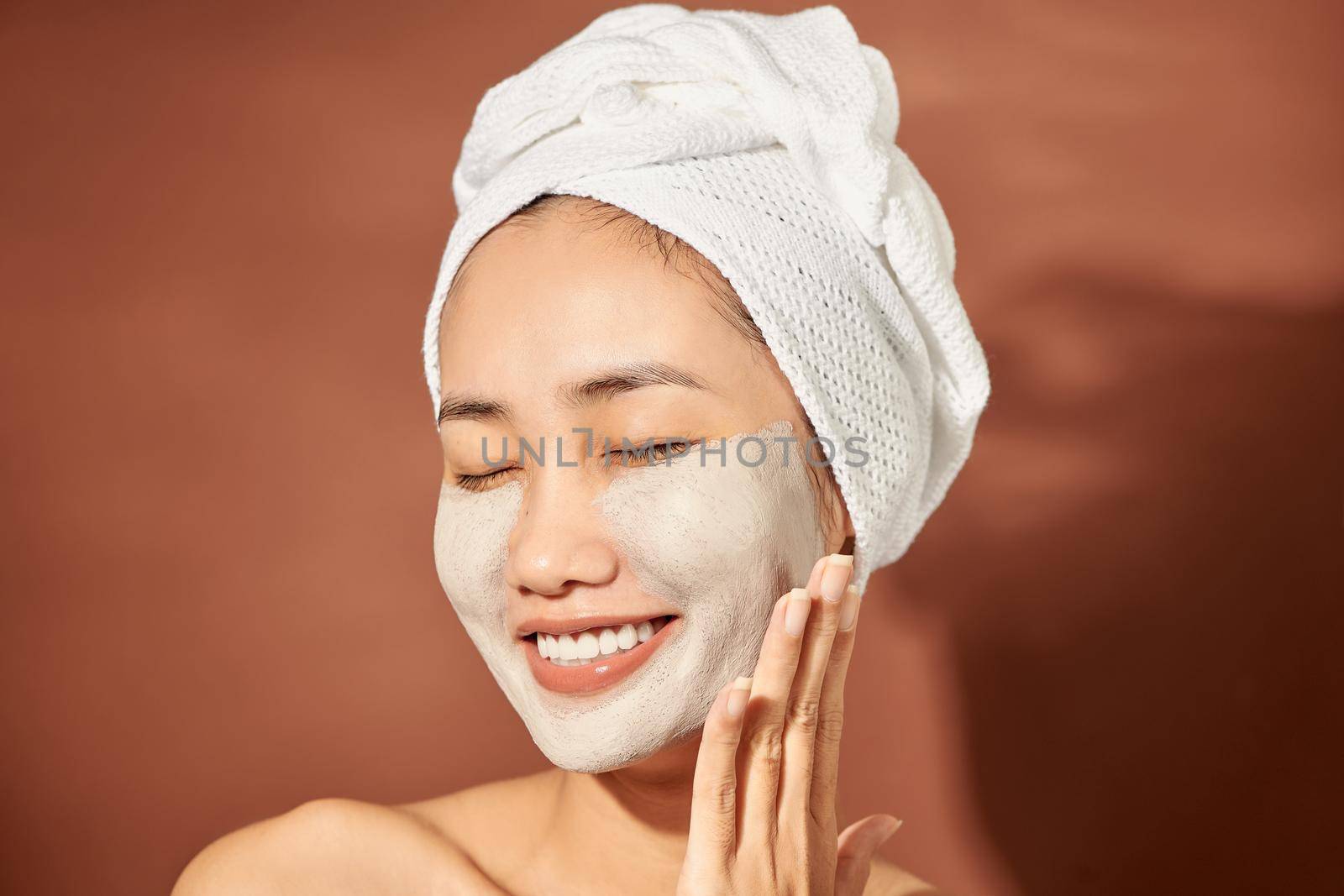 Spa Woman applying Facial clay Mask. Beauty Treatments. 