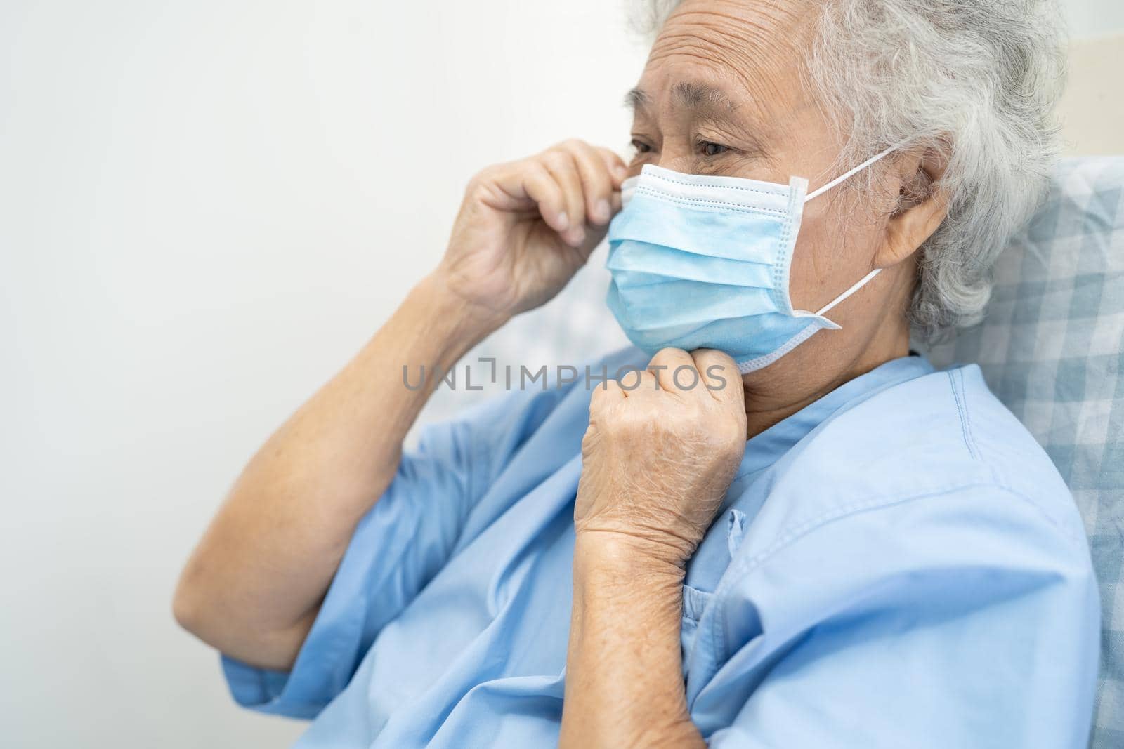 Asian senior or elderly old lady woman patient wearing a face mask new normal in hospital for protect safety infection Covid-19 Coronavirus.