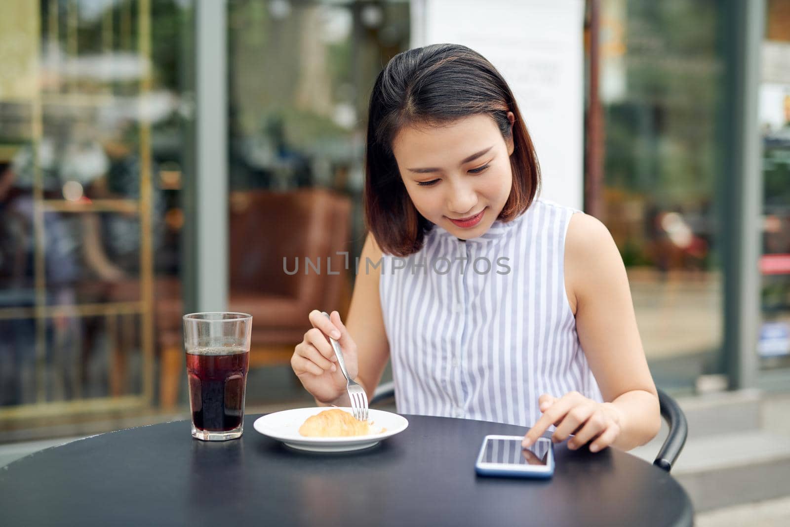 Asian woman using smartphone in coffee shop cafe by makidotvn