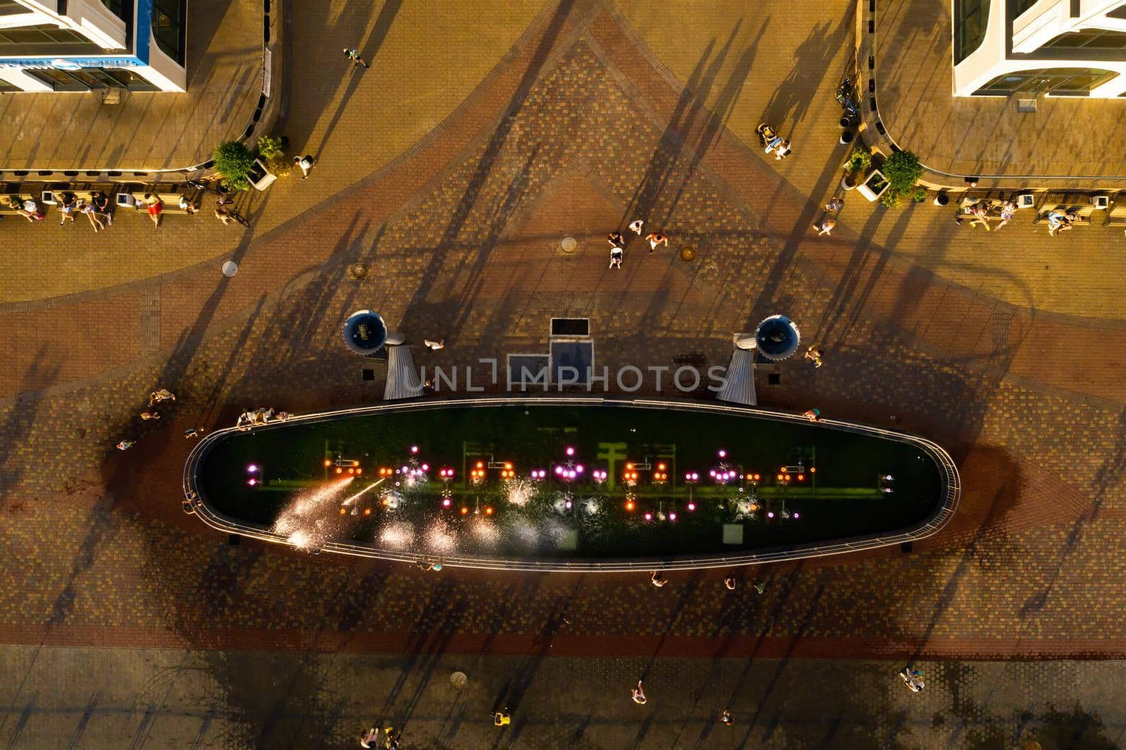 Top view of the city fountain in the new district of Minsk Mayak hot summer and vacationing people.People relax and walk near a large fountain in the city.Belarus by Lobachad