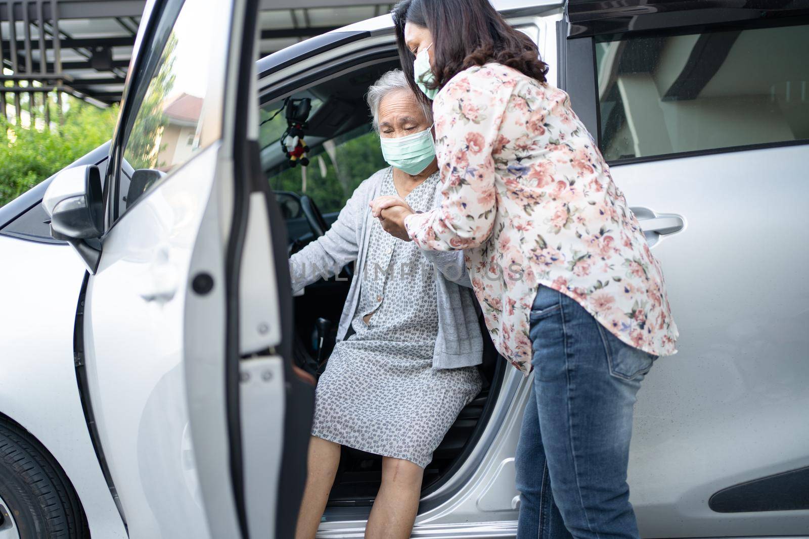 Help and support asian senior or elderly old lady woman patient sitting on wheelchair prepare get to her car, healthy strong medical concept. by pamai