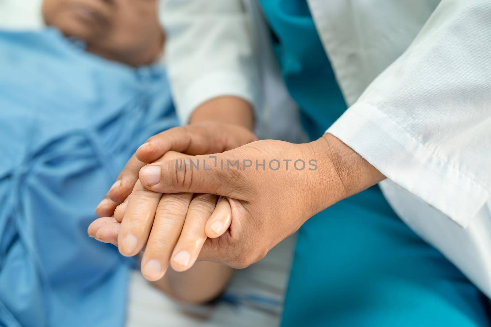 Doctor holding touching hands Asian senior or elderly old lady woman patient with love, care, helping, encourage and empathy at nursing hospital ward, healthy strong medical concept by pamai