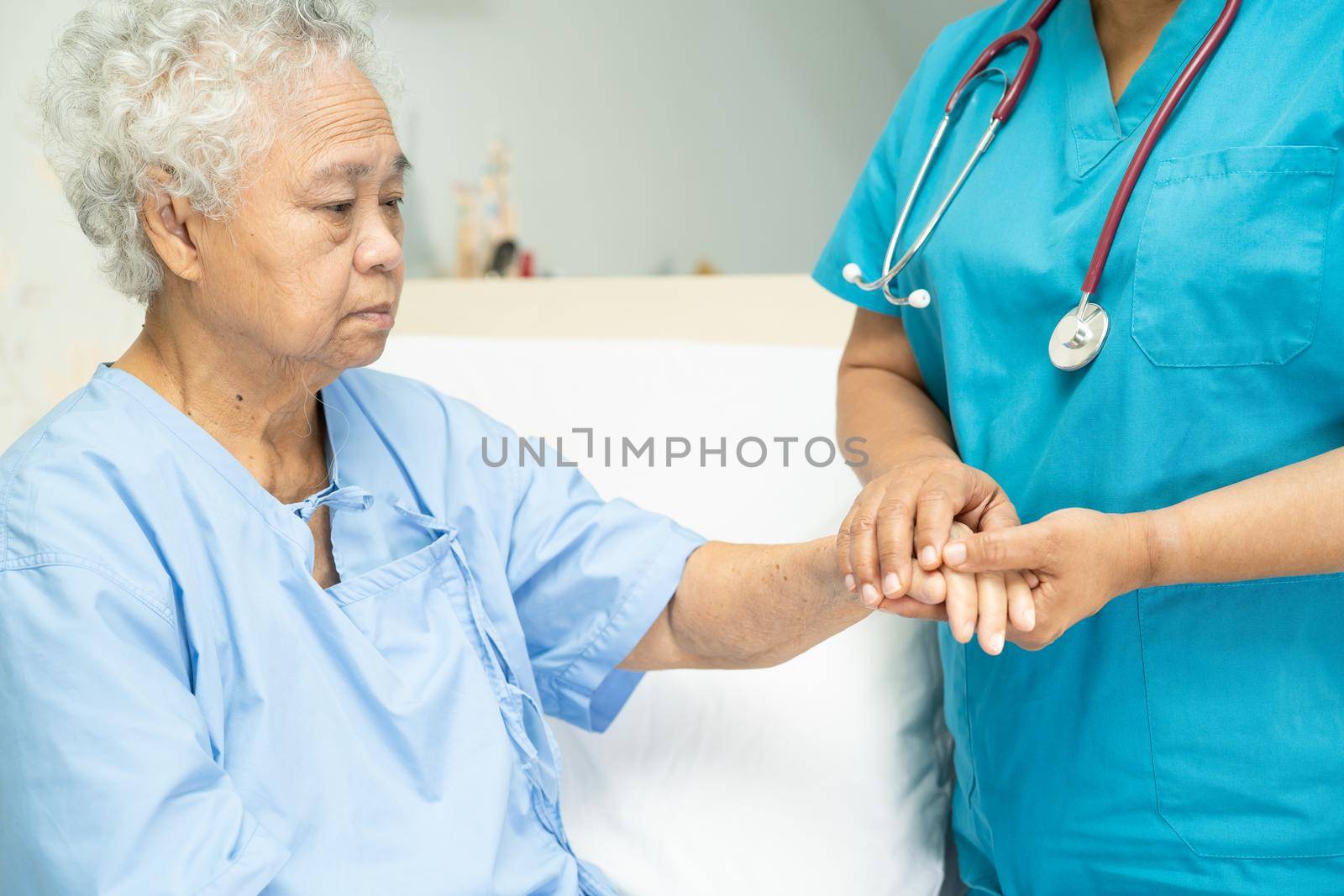 Touching Asian senior or elderly old lady woman patient with love, care, helping, encourage and empathy at nursing hospital ward : healthy strong medical concept by pamai