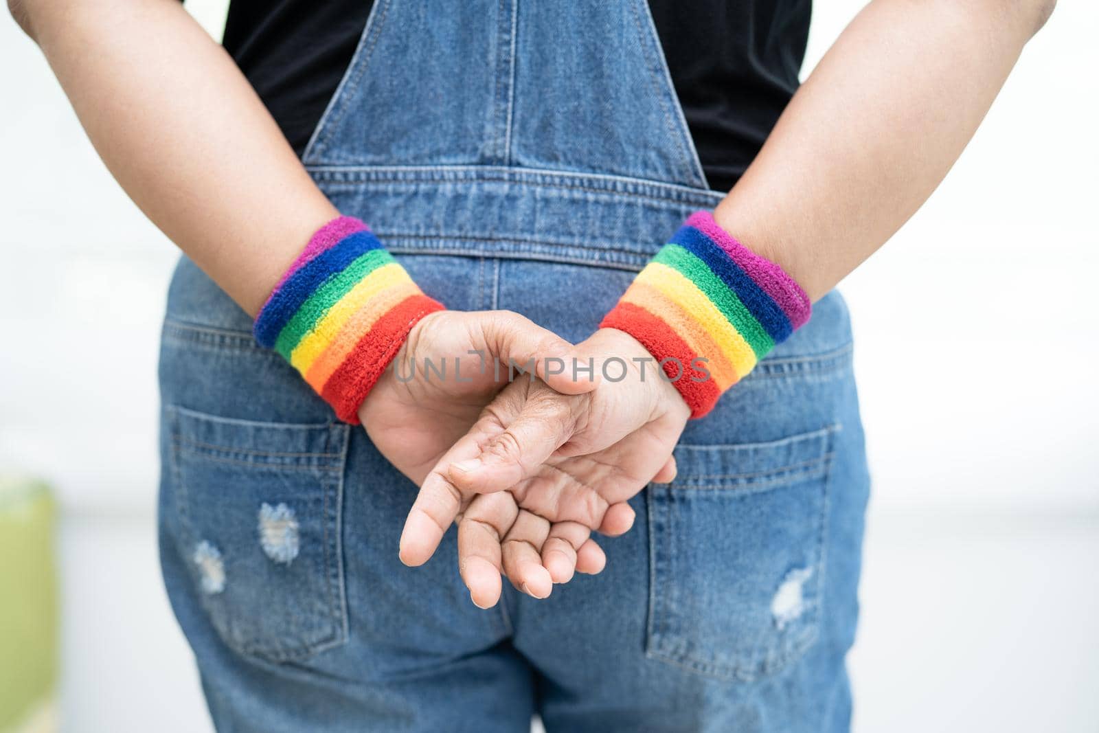 Asian lady wearing rainbow flag wristbands, symbol of LGBT pride month celebrate annual in June social of gay, lesbian, bisexual, transgender, human rights. by pamai