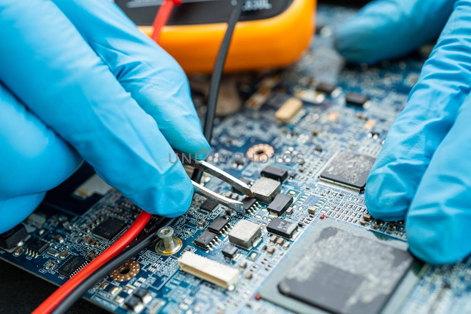technician repairing inside of hard disk by soldering iron. Integrated Circuit. the concept of data, hardware, technician and technology. by pamai