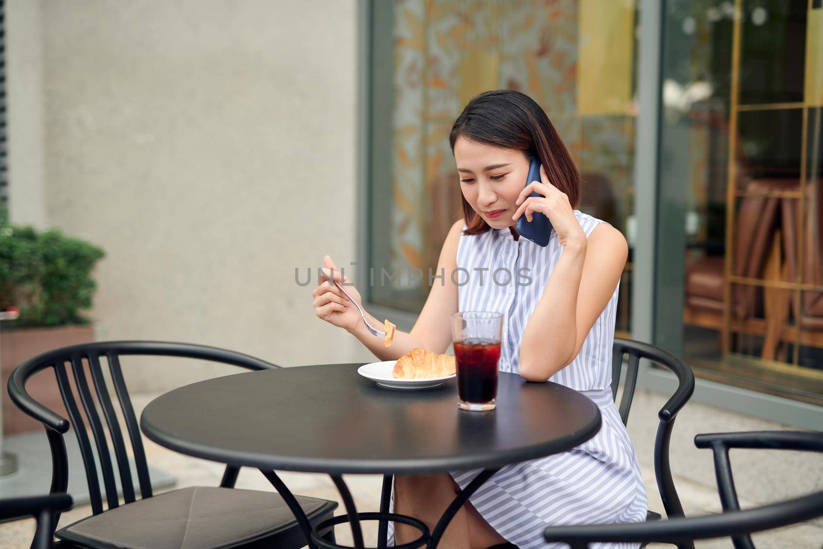 Elegant girl calling someone while resting in outdoor cafe by makidotvn