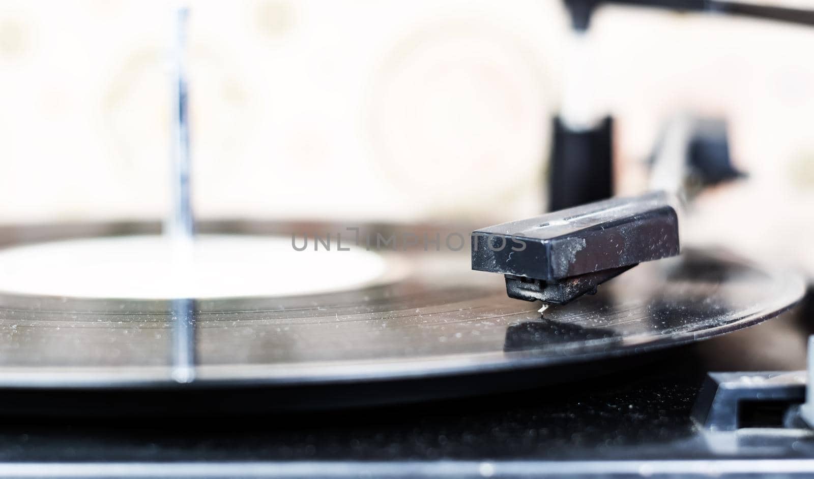 the needle of a turntable playing the tracks of a black vinyl record. Vintage audio equipment. Vinyl record player