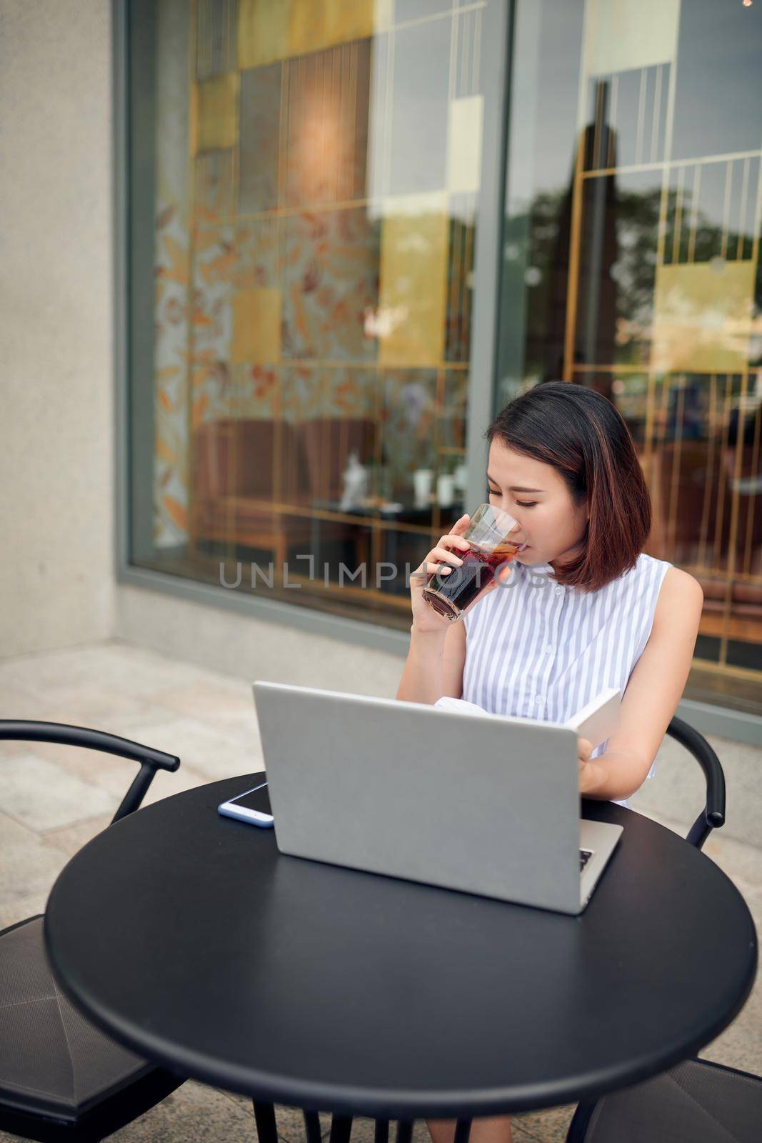 Beauty asian woman sitting holding glass cup of coffee with her hand in coffee shop