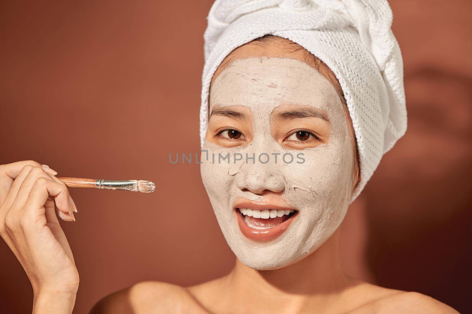 Spa Woman applying Facial clay Mask. Beauty Treatments. 