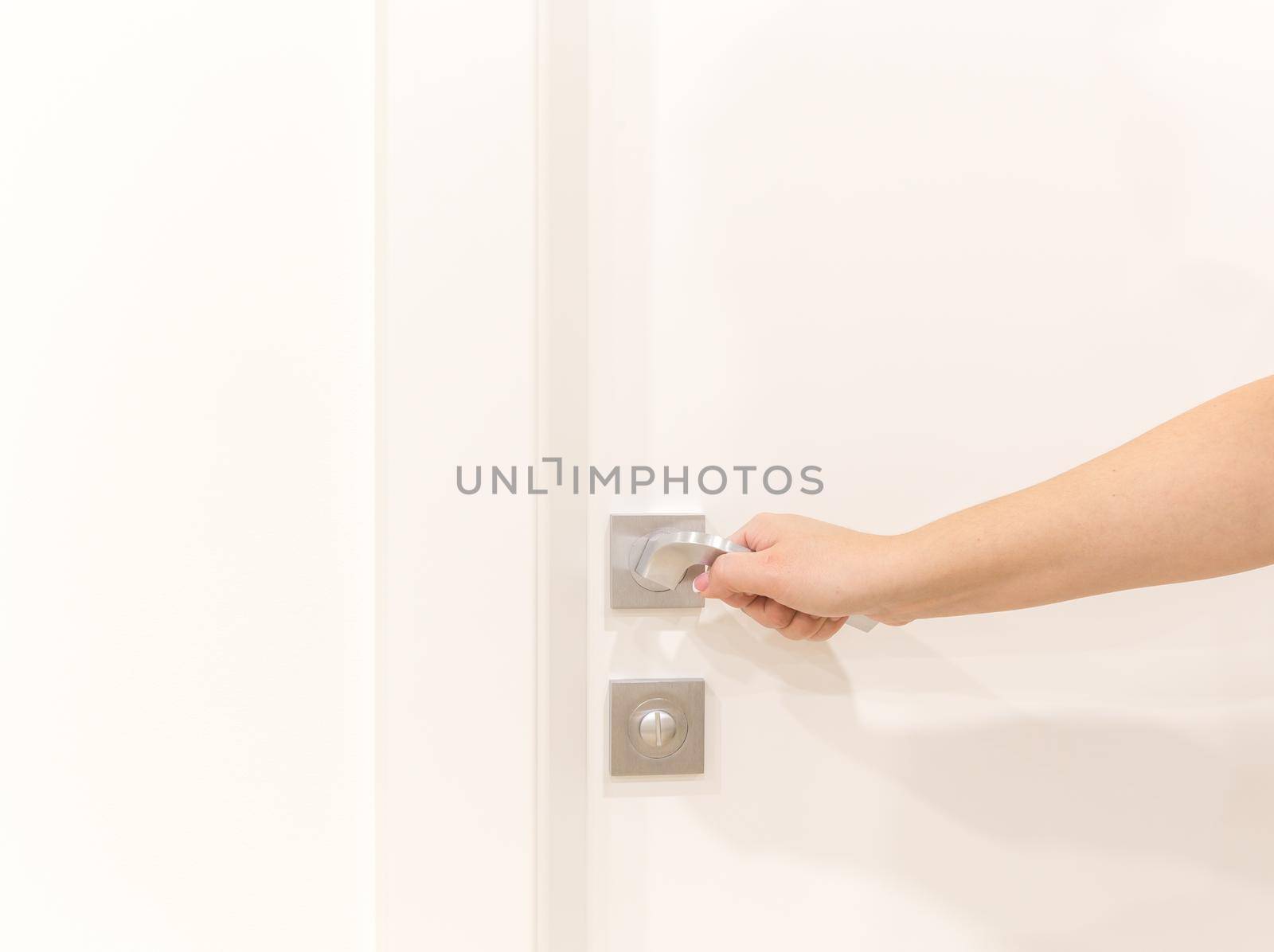 Woman's hand opening door in bedroom