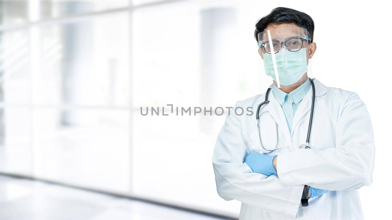 Asian doctor wearing face shield and PPE suit new normal to check patient protect safety infection Covid-19 Coronavirus outbreak at quarantine nursing hospital; for header banner by pamai