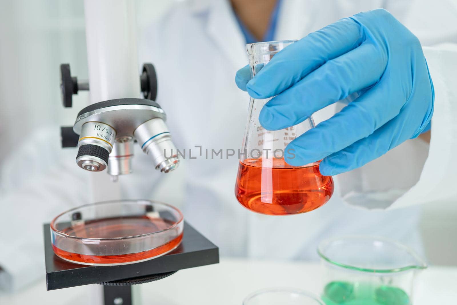 Asian scientist biochemist or microbiologist working research with a microscope in laboratory. For protect outbreak Coronavirus Covid19, bacteria and germs.