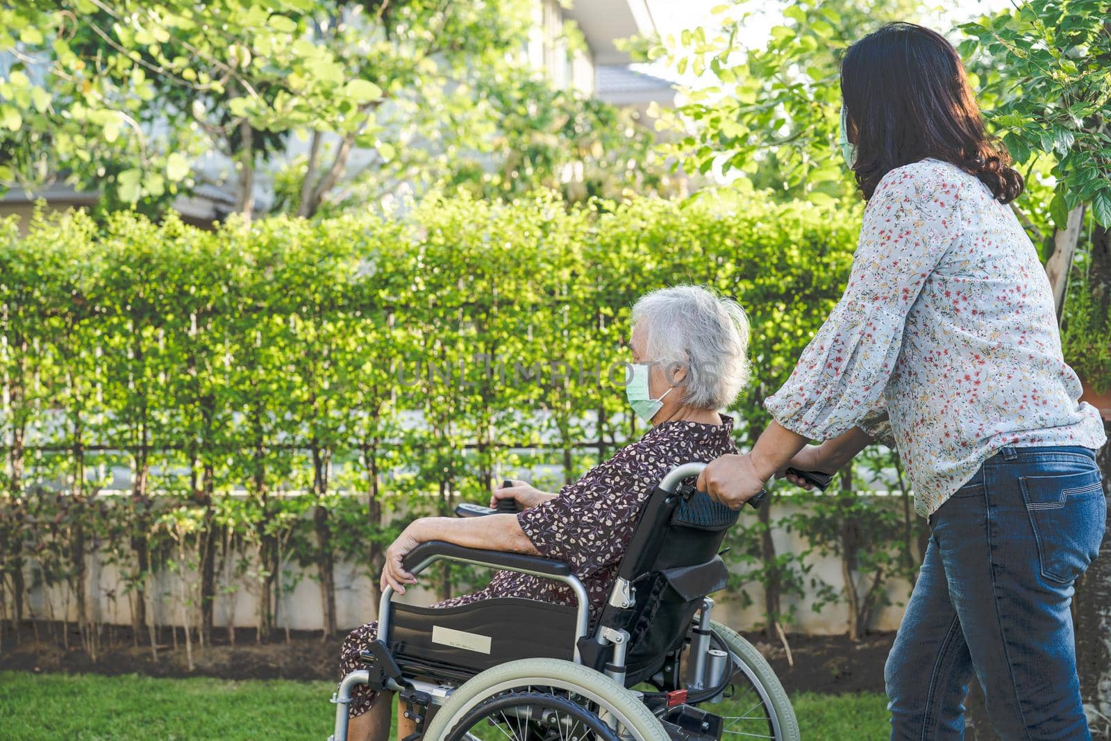 Doctor help and care Asian senior or elderly old lady woman patient sitting on wheelchair at park in nursing hospital ward, healthy strong medical concept.