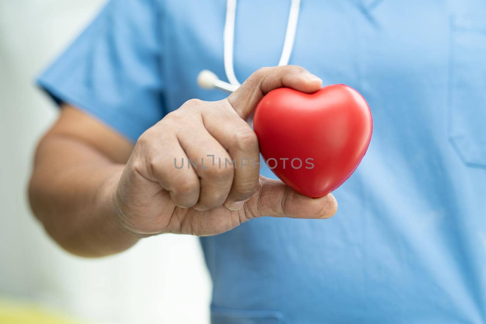Asian senior or elderly old lady woman patient holding red heart in her hand on bed in nursing hospital ward, healthy strong medical concept